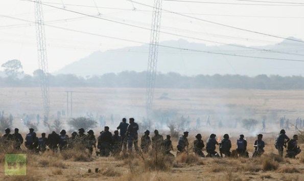 Policemen fire at striking miners outside a South African mine in Rustenburg